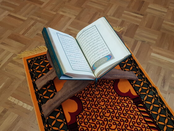 Gebetsteppich mit aufgeschlagenem Koran auf Koranständer